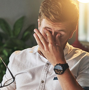Man holding eye glasses rubbing eyes due to pink eye